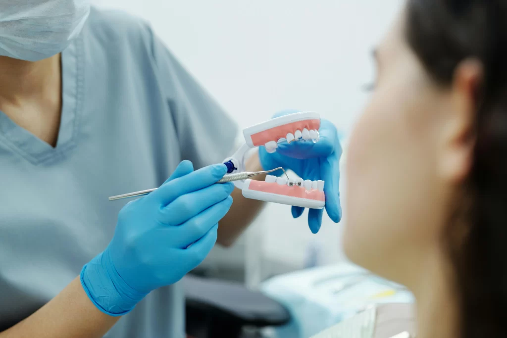 A dentist is showing a teeth guide to the patient.
