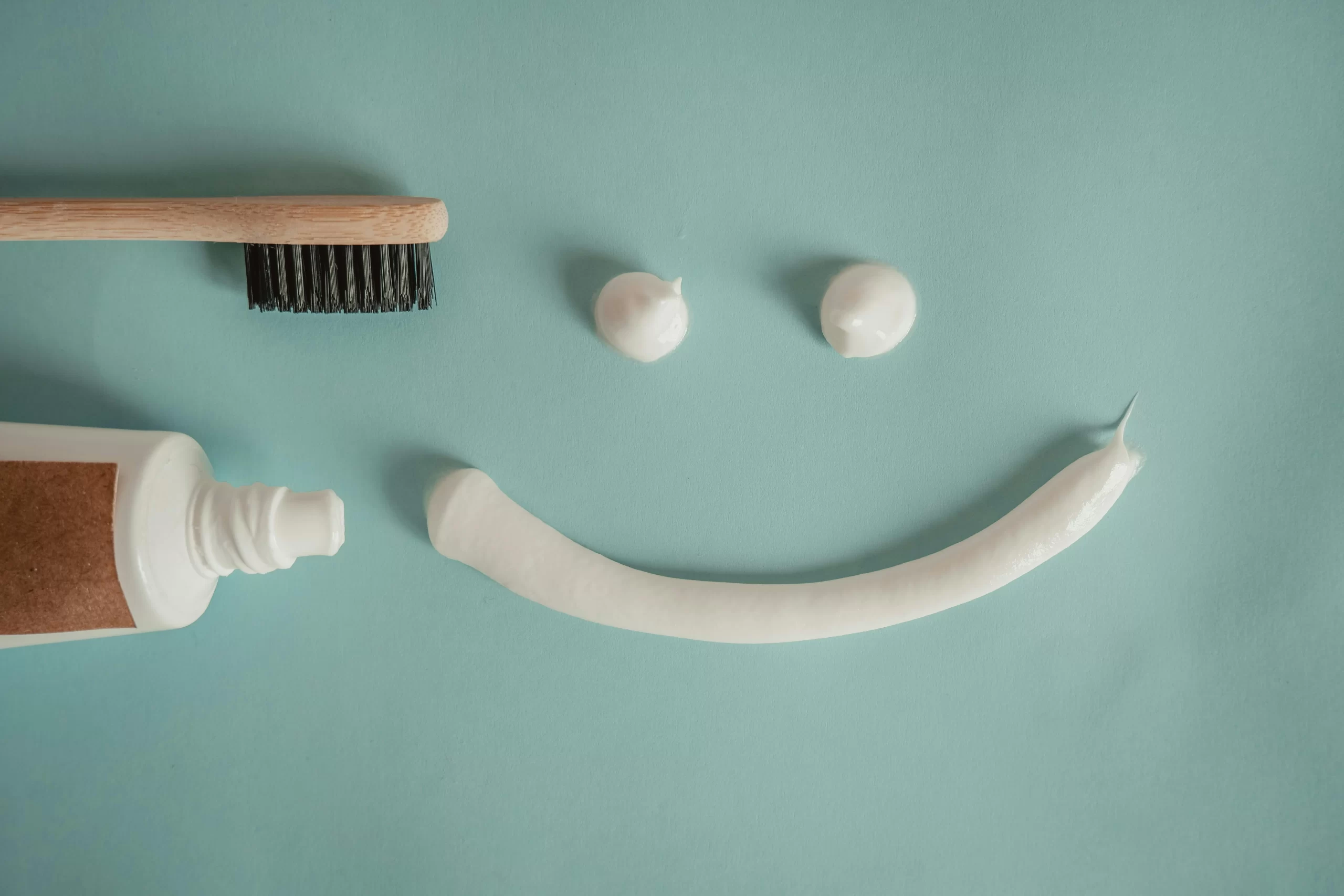 A toothbrush and a tube of toothpaste with a painted smile; common teeth whitening kit at home