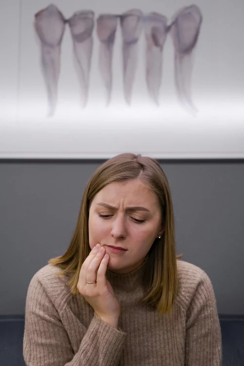 A woman in pain holding her cheek.